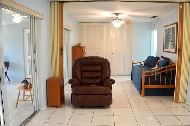 living area featuring ceiling fan and light tile patterned floors