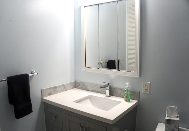 half bathroom featuring toilet and vanity