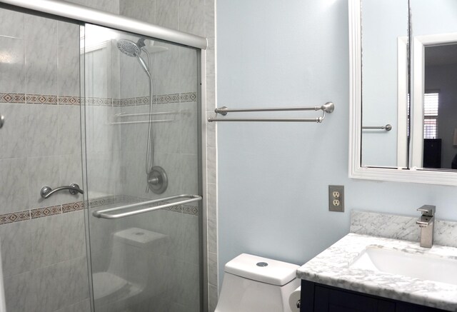 bathroom featuring vanity, toilet, and walk in shower