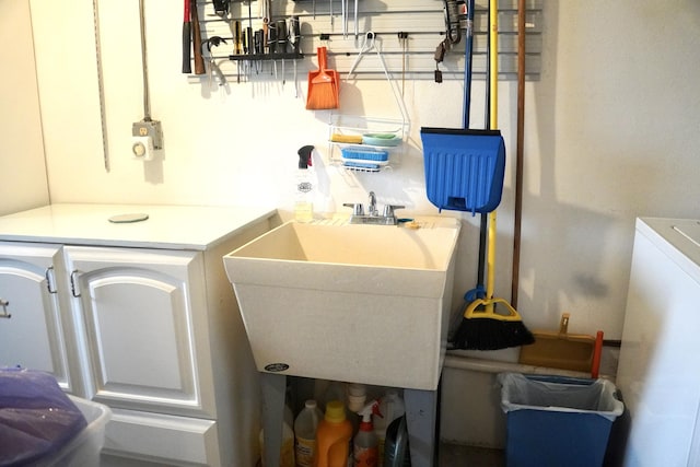 laundry area with a sink and washer / dryer