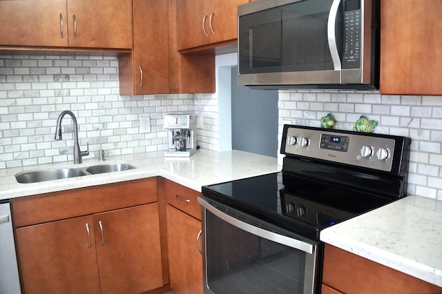 kitchen with a sink, brown cabinetry, backsplash, and stainless steel appliances