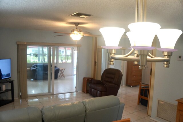 living room with a textured ceiling, ceiling fan, and light tile patterned flooring