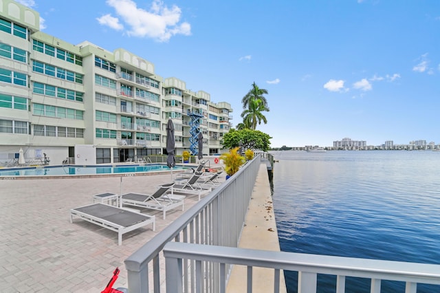 dock area featuring a water view and a community pool