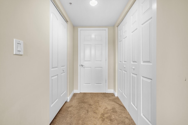 corridor featuring carpet floors and baseboards