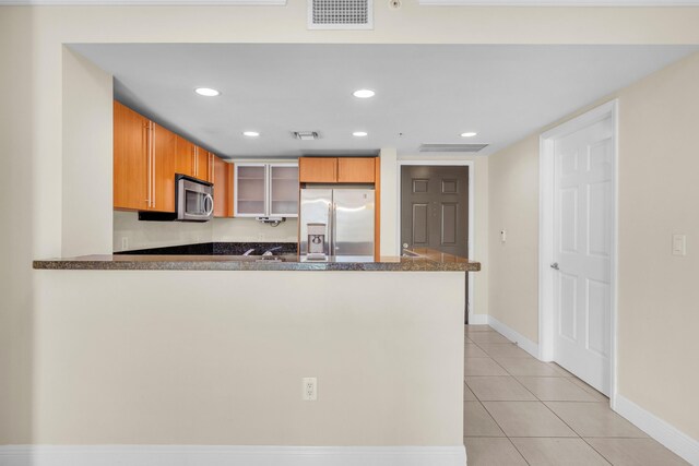 kitchen featuring appliances with stainless steel finishes, kitchen peninsula, and light tile patterned floors