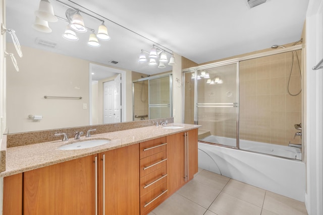 full bathroom featuring double vanity, visible vents, combined bath / shower with glass door, a sink, and tile patterned floors