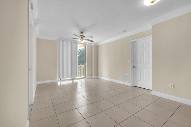 tiled empty room with ceiling fan, crown molding, and a textured ceiling