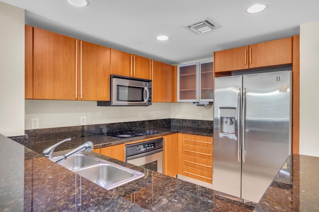 kitchen with stainless steel appliances, recessed lighting, visible vents, glass insert cabinets, and a sink