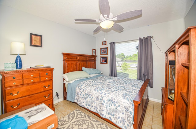 bedroom featuring light tile patterned flooring, ceiling fan, and a textured ceiling