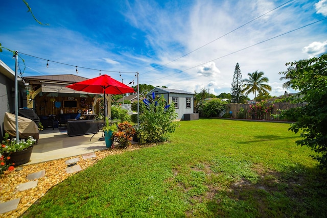 view of yard with an outbuilding, a patio area, and a fenced backyard