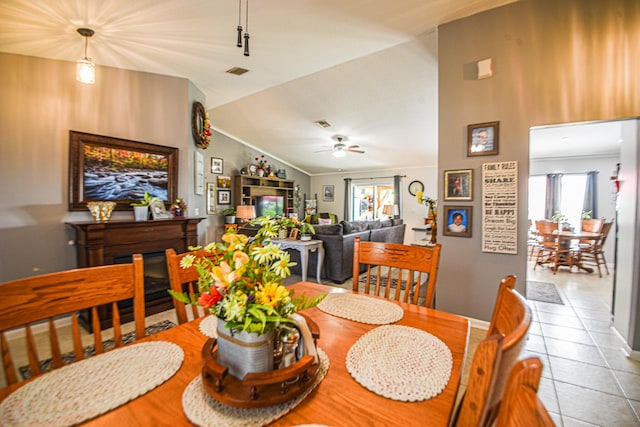 dining room featuring visible vents, ornamental molding, vaulted ceiling, and tile patterned floors