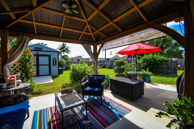 view of patio / terrace featuring a gazebo, a shed, an outdoor structure, and a fenced backyard