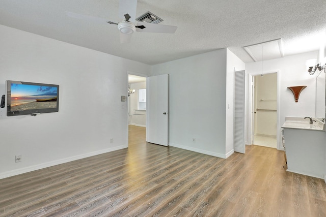 unfurnished living room featuring ceiling fan, a textured ceiling, and hardwood / wood-style floors