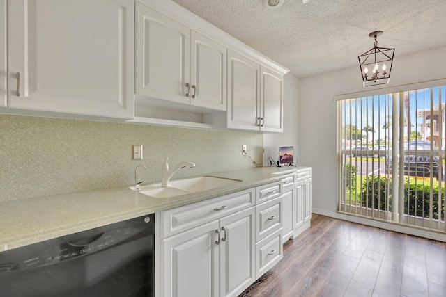 kitchen with white cabinetry, black dishwasher, wood-type flooring, an inviting chandelier, and sink