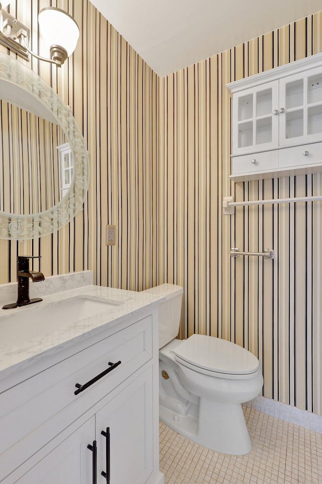 bathroom featuring tile patterned flooring, vanity, and toilet