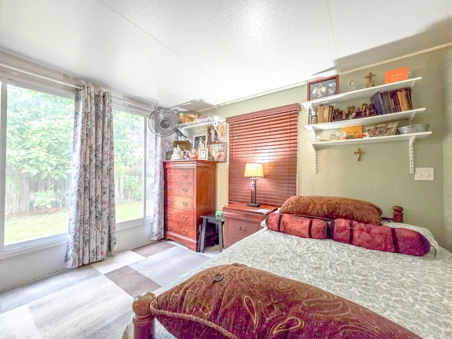 bedroom with multiple windows and light carpet