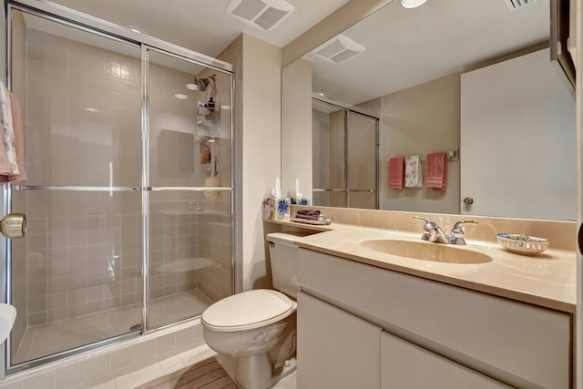 bathroom with a shower with door, toilet, and vanity