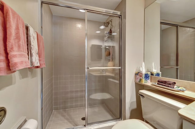 bathroom with a shower with shower door, vanity, and toilet