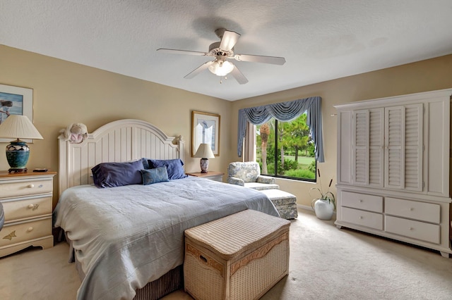 bedroom featuring ceiling fan, a textured ceiling, and light colored carpet