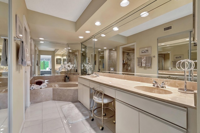 bathroom with dual bowl vanity, tiled bath, and tile patterned flooring