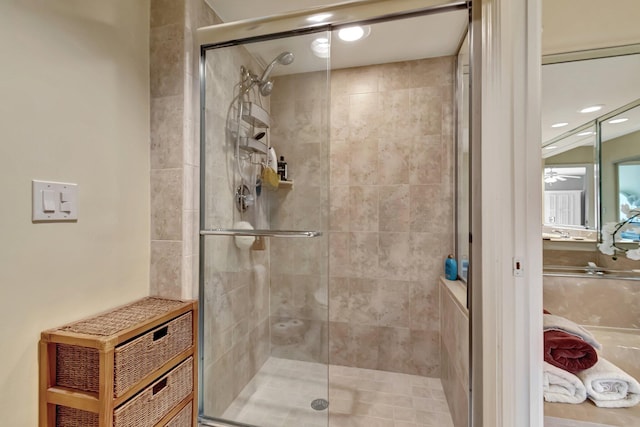 bathroom featuring ceiling fan and a shower with door