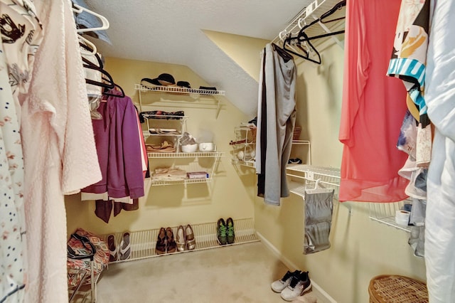 walk in closet with lofted ceiling and carpet floors