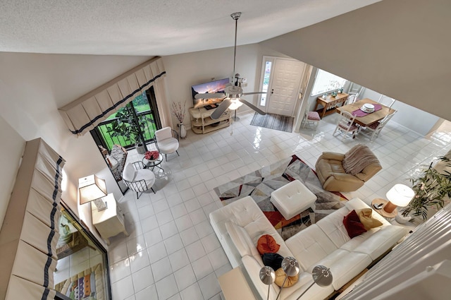 tiled living room featuring a textured ceiling and high vaulted ceiling