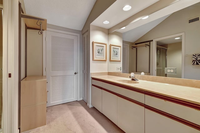 bathroom with vanity and lofted ceiling