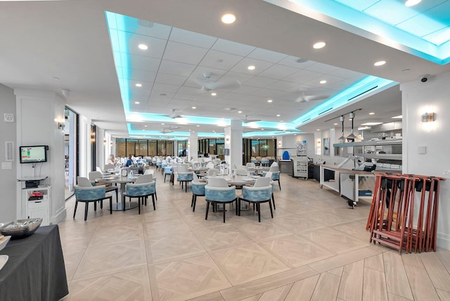 dining space with a raised ceiling and light tile patterned floors