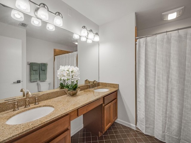 bathroom featuring toilet, vanity, and tile patterned floors