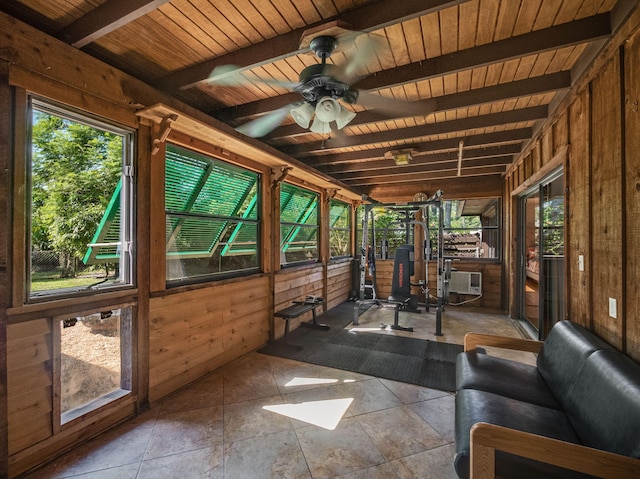 unfurnished sunroom featuring beamed ceiling, ceiling fan, and wooden ceiling