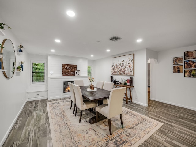 dining area featuring a fireplace and wood-type flooring