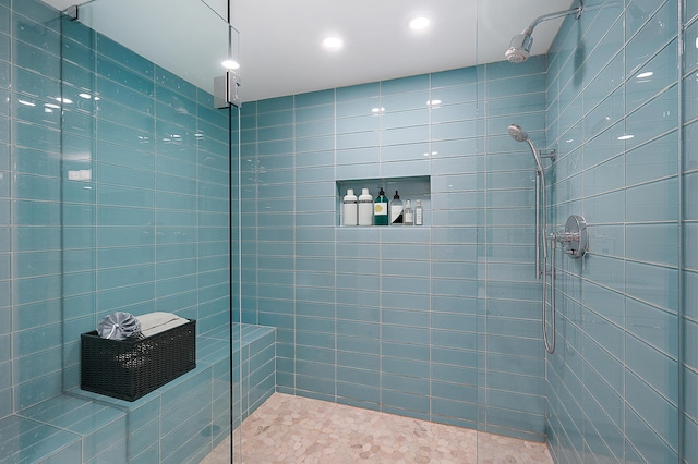 bathroom with tiled shower and tile patterned floors