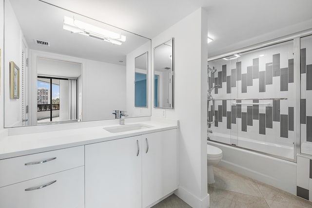 full bathroom with vanity, combined bath / shower with glass door, tile patterned floors, and toilet