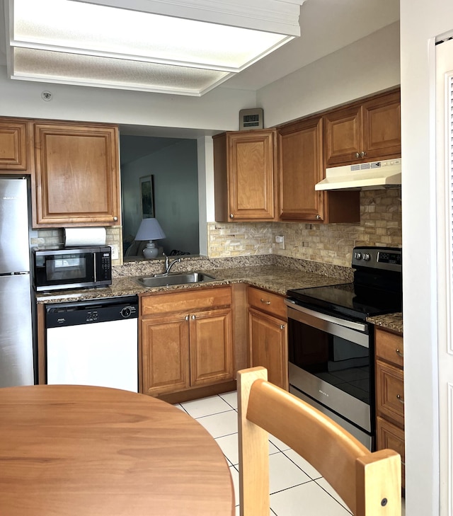 kitchen featuring light tile patterned floors, appliances with stainless steel finishes, sink, and backsplash