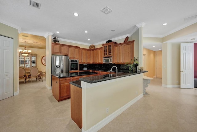 kitchen featuring stainless steel appliances, tasteful backsplash, ornamental molding, an inviting chandelier, and kitchen peninsula