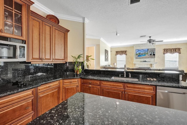 kitchen featuring appliances with stainless steel finishes, a textured ceiling, sink, and a wealth of natural light