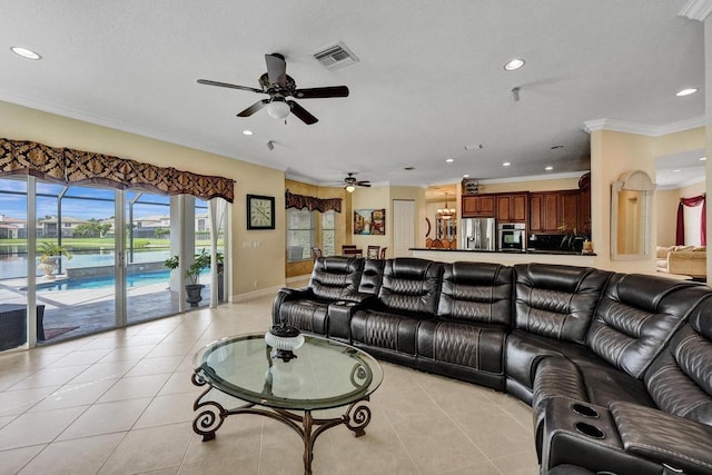 tiled living room with ceiling fan and crown molding