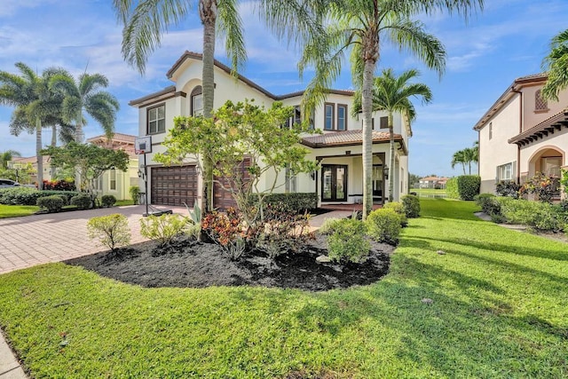 mediterranean / spanish-style home with a front lawn and a garage