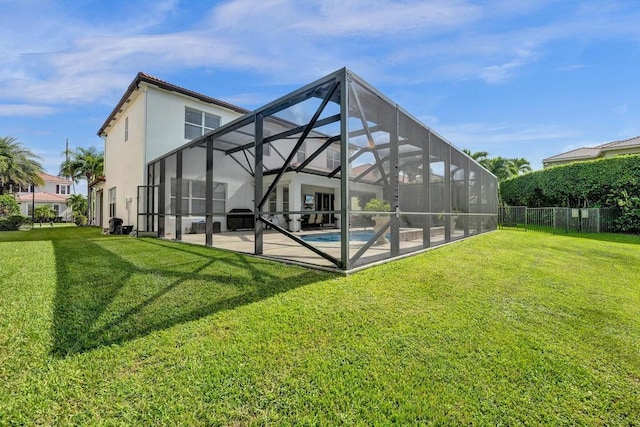 back of property with a patio, a yard, and glass enclosure