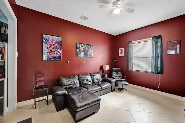 living room with a textured ceiling, light tile patterned floors, and ceiling fan