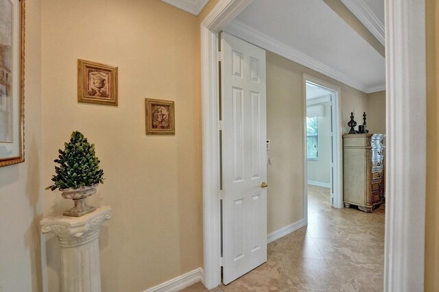 hallway with light tile patterned flooring and ornamental molding