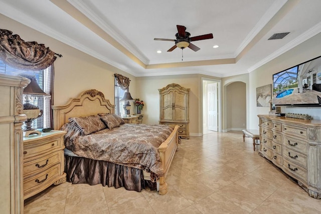 tiled bedroom featuring a tray ceiling, crown molding, and ceiling fan