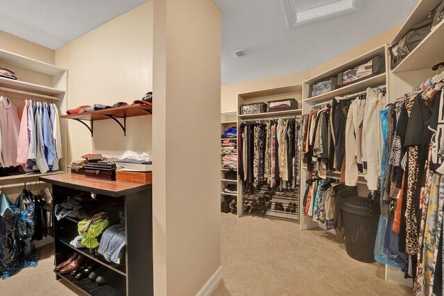 walk in closet with light tile patterned floors