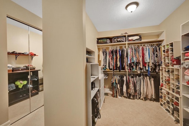 walk in closet with light tile patterned floors