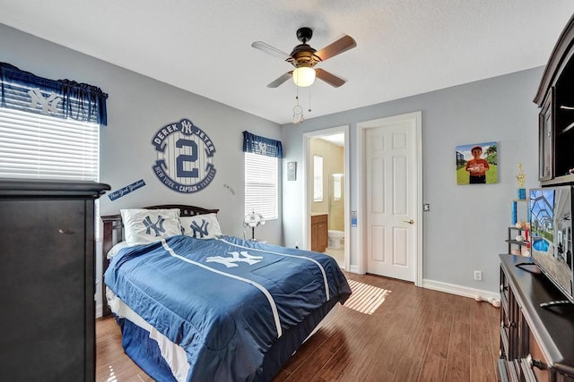 bedroom with ensuite bath, dark hardwood / wood-style flooring, and ceiling fan