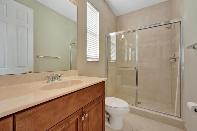 bathroom featuring a shower with door, toilet, vanity, and tile patterned flooring