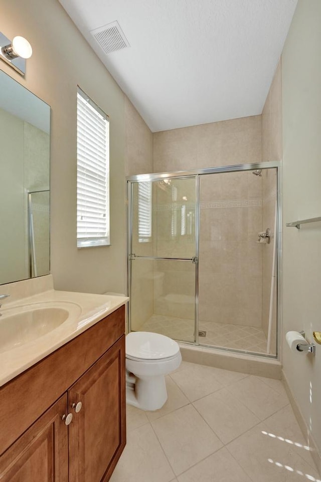 bathroom featuring an enclosed shower, toilet, vanity, and tile patterned flooring