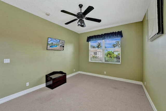 spare room featuring ceiling fan and carpet