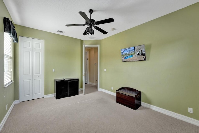 interior space with ceiling fan and carpet